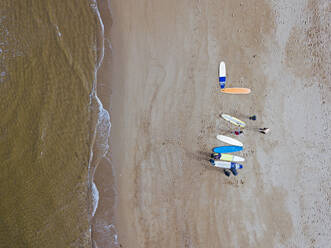 Luftaufnahme von Surfern bei der Vorbereitung auf den Sandstrand an der Küste - KNTF04955