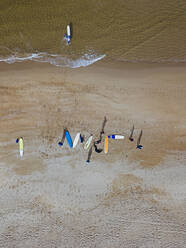 Luftaufnahme von Surfern bei der Vorbereitung auf den Sandstrand an der Küste - KNTF04957