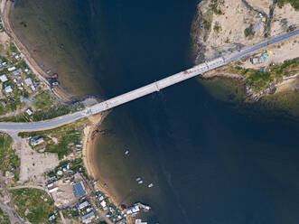 Russia, Murmansk Oblast, Teriberka, Aerial view of coastal village bridge - KNTF04968