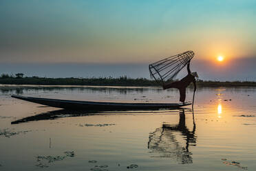 Fischer am Inle-See mit traditionellem konischem Intha-Netz bei Sonnenuntergang, Fischernetz, Beinruderstil, Intha-Volk, Inle-See, Shan-Staat, Myanmar (Burma), Asien - RHPLF15523