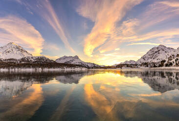 Farben des Sonnenuntergangs spiegeln sich auf der eisigen Oberfläche des Silsersees, Engadin, Graubünden, Schweiz, Europa - RHPLF15588