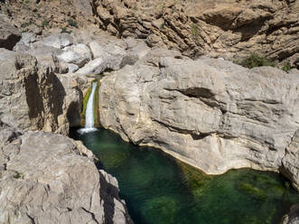 Wasserfall, der in ein natürlich geformtes Schwimmbecken im Wadi Bani Khalid, Sultanat Oman, Naher Osten, fällt - RHPLF15649