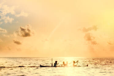 Local boys on a wooden canoe at sunset, Banda, Maluku, Spice Islands, Indonesia, Southeast Asia, Asia - RHPLF15666