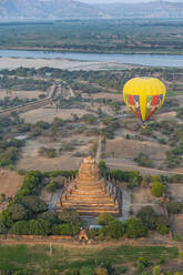 Heißluftballon bei Sonnenaufgang über einem Tempel, Bagan (Pagan), Myanmar (Burma), Asien - RHPLF15738