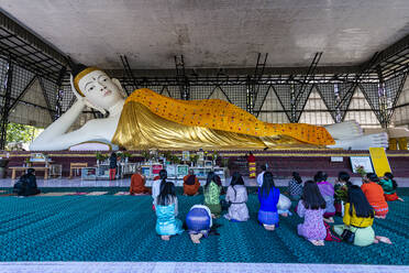 Pilgrims praying before a reclining Buddha, Su Taung Pyi pagoda, Myitkyina, Kachin state, Myanmar (Burma), Asia - RHPLF15756