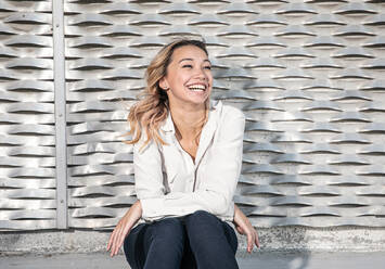 Portrait of A Young Woman with Big Smile in Front of Metallic Wall - CAVF86875
