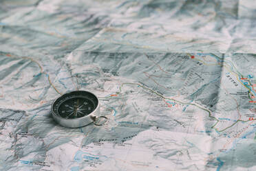 Planung der Route auf einer Karte und einem Kompass - CAVF86906