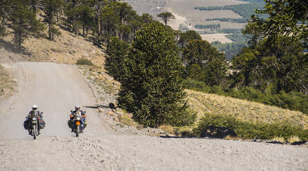 Couple on touring motorbikes driving on gravel road in Argentina - CAVF87015