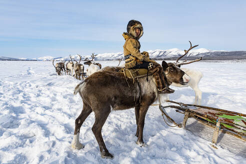 Ewenken-Junge auf einem Rentier sitzend, Oymyakon, Republik Sacha (Jakutien), Russland, Eurasien - RHPLF15918
