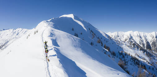 A team of three skiers advances on the mountain ridge, Mount Meriggio, Valtellina, Lombardy, Italy, Europe - RHPLF15981