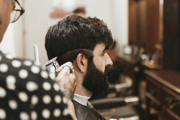 Friseur schneidet einem Mann die Haare im Salon - XLGF00362