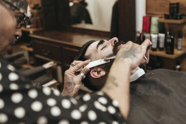 Trendy Barbier schneidet Bart eines Mannes im Salon - XLGF00373