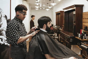 Trendy Friseur Befestigung Umhang auf männlichen Kunden im Salon - XLGF00381