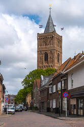 Niederlande, Südholland, Noordwijk, Leere Stadtstraße mit Turm der Oude Jeroenskerk Kirche im Hintergrund - TAMF02511