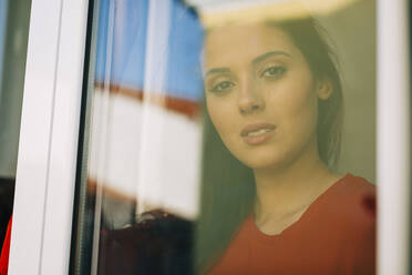 Close-up of young woman seen through glass door - DCRF00369