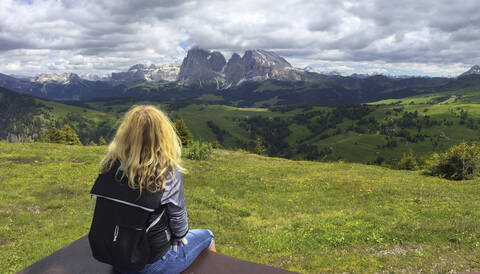 Italien, Südtirol, Seis am Schlern, Blonde Frau bewundert die malerische Landschaft der Seiser Alm, lizenzfreies Stockfoto