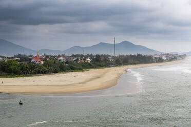 Vietnam, Da Nang, Cloudy sky over beachside village in Hai Van Pass - RUNF03843