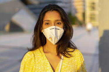 Selbstbewusste junge Frau mit Gesichtsmaske in der Stadt - AFVF06790