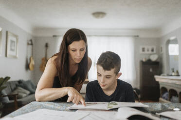 Mutter unterrichtet Sohn während der Ausgangssperre zu Hause auf dem Tisch - SMSF00045