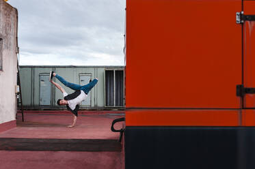 Mann breakdancing auf verlassenen Gebäude Terrasse gegen Himmel - JMPF00193