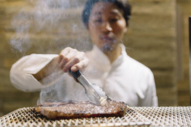 Chef cooking in restaurant preparing beef roast - ADSF01237
