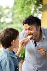 Boy and father eating bread - CUF55778