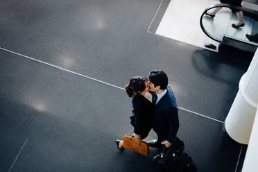Paar in Geschäftsanzügen küssend - CUF55824
