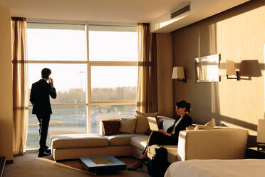 Geschäftsmann und Geschäftsfrau arbeiten im Hotelzimmer - CUF55834
