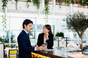 Businessman and businesswoman having drink at bar - CUF55889