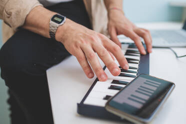 High angle close up of man playing on keyboard. - CUF56099