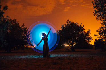 Female silhouette in glowing circle in nature - ADSF01383