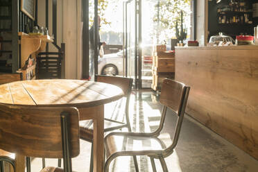 Holztisch in einem leeren Cafe in Toulouse an einem sonnigen Tag niemand - CAVF87120
