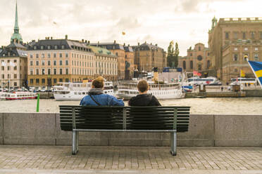 Zwei Frauen sitzen bei Gamla Stan auf dem Wasser - CAVF87174