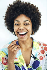 Fröhliche erwachsene Frau mit Afrofrisur vor weißem Hintergrund - EHF00577