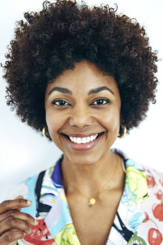 Glückliche Frau mit Afrofrisur vor weißem Hintergrund, lizenzfreies Stockfoto