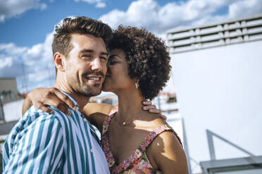 Romantic woman kissing man on cheek during sunny day - EHF00610