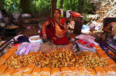 Adivasi-Frau verkauft frisch zubereitete Pakora auf einem traditionellen Dorffest zum Holi-Fest, Gujarat, Indien, Asien - RHPLF16063