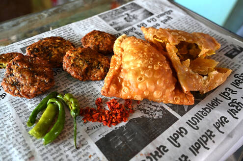 Köstliche typische Gujarati-Snacks am Straßenrand, pakora, methi gotha, grüner Chili und rote Chiliflocken, Gujarat, Indien, Asien - RHPLF16074