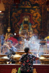 Chinese man burning incense and praying to a prosperous future, Guan Di Chinese Taoist Temple, Kuala Lumpur, Malaysia, Southeast Asia, Asia - RHPLF16087