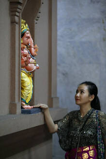Frau betet zur Hindu-Gottheit Ganesh-Statue, Sri Mahamariamman Hindu-Tempel, Kuala Lumpur, Malaysia, Südostasien, Asien - RHPLF16093
