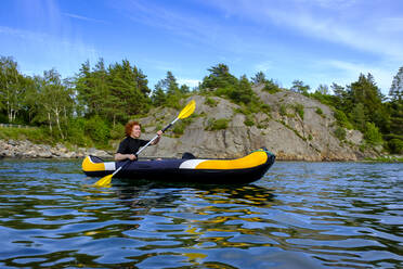 Sweden, Vastra Gotaland County, Kyrkesund, Teenage boy kayaking near coast of Lilla Askeron island - LBF03145