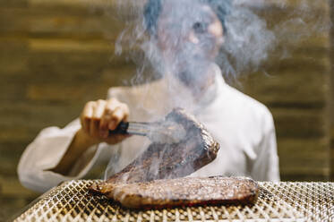 Chef cooking in restaurant preparing beef roast - ADSF01397