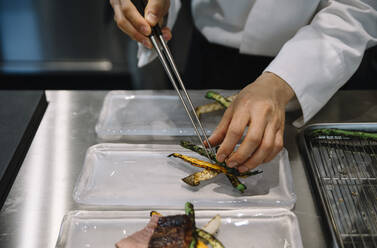 Chefkoch im Restaurant bereitet die Gerichte mit Stäbchen zu - ADSF01400