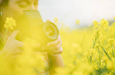 Frau Retro-Kamera machen Foto in der Natur mit gelben Blumen Großaufnahme - ADSF01448