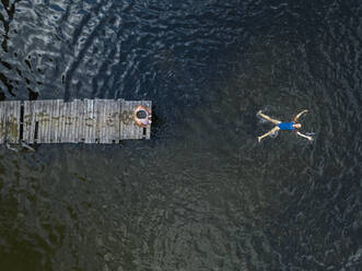 Luftaufnahme von Mann und Frau beim Schwimmen im See - KNTF04990