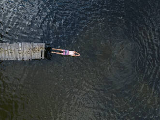 Luftaufnahme eines in den See springenden Mannes - KNTF04993