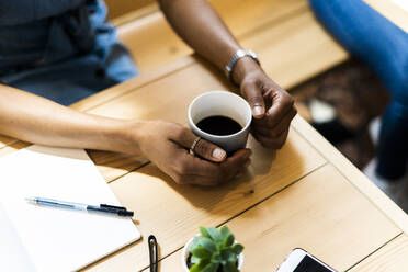 Hohe Winkel Ansicht der Frau hält schwarzen Kaffee am Tisch im Café - GIOF08545