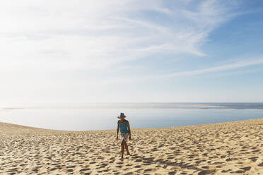 Frau auf Sanddünen am Strand gegen den Himmel, Düne von Pilat, Nouvelle-Aquitaine, Frankreich - GWF06627