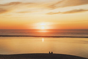 Silhouette couple watching sunset at Atlantic ocean, Dune of Pilat, Nouvelle-Aquitaine, France - GWF06638
