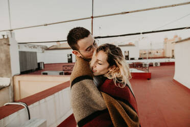 Paar in Umarmung mit Decke auf einer Terrasse - ADSF01508